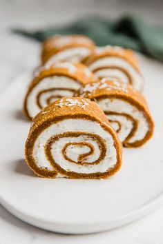 there is a white plate with some cinnamon roll on it and one has been cut in half