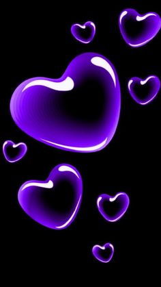 purple hearts floating in the air on a black background