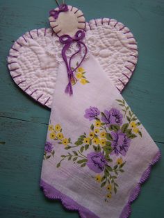 an angel ornament with purple flowers on it