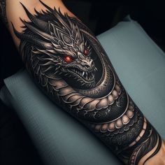 a man's arm with a dragon tattoo on it and an eye in the middle