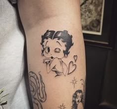 a woman's arm with tattoos on it and an image of a teddy bear