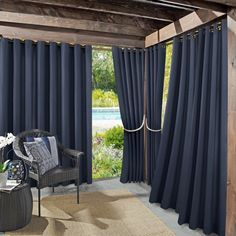 a living room filled with furniture and windows covered in dark blue drapes next to a pool