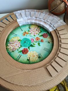 a clock made out of cardboard with flowers painted on it