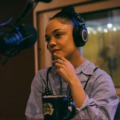 a woman wearing headphones sitting in front of a microphone