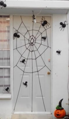 a white door decorated with halloween decorations and spider webs on it's side