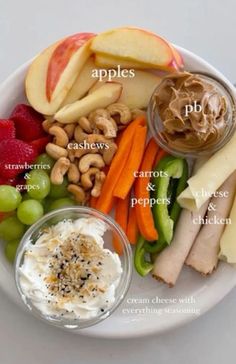 a white plate topped with different types of fruits and vegetables next to dips on top of each other