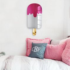 a bed with pink pillows and a mirror on the wall