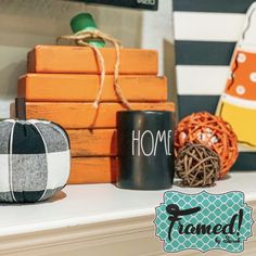 some pumpkins sitting on top of a white mantle next to orange boxes and other decorations