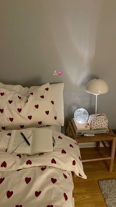 a laptop computer sitting on top of a bed next to a lamp and pillow case