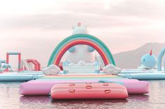 an inflatable water park with rainbows and unicorns floating on the water