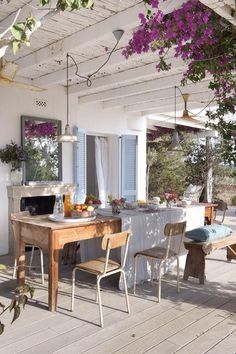 an outdoor dining area with table, chairs and potted plants on the deck outside