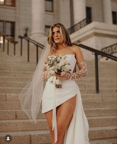 a woman in a wedding dress is walking down the stairs