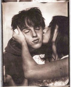 a man and woman kissing each other in an old black and white photo with two pictures behind them