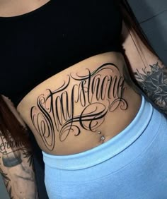 a woman's stomach with the word stay strong on it and an arrow tattoo