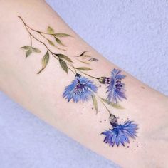 a blue flower tattoo on the arm