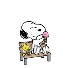 a snoopy sitting on a bench eating an ice cream cone