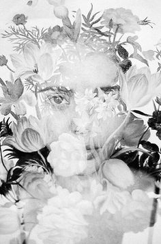 a black and white photo of a woman's face surrounded by flowers