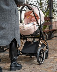 a woman standing next to a baby in a stroller