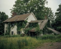 an old abandoned house with vines growing on it