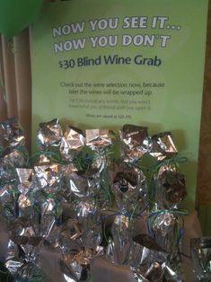 there are many bags of wine wrapped in foil and tied to the table for sale