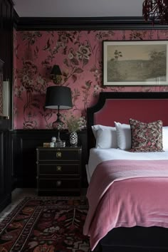 a bedroom with pink walls and floral wallpaper, along with a large bed in the center