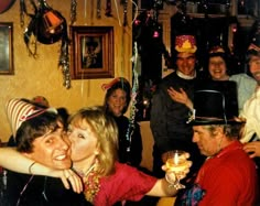 a group of people standing next to each other in a room with balloons and streamers