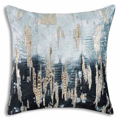 a blue and gold pillow with metallic foil on the front, along with black background