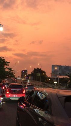 many cars are driving down the street at dusk