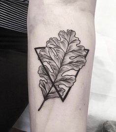 a black and white photo of a leaf tattoo