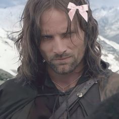 a man with long hair and a pink bow on his head