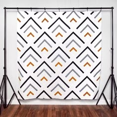 a white wall with an orange and black geometric pattern on it, hanging from the ceiling