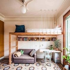 a living room with a couch, desk and bookshelf in the middle of it