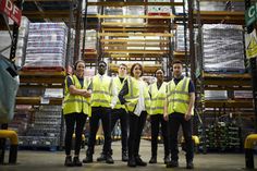 group of workers in warehouse posing for the camera