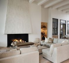 a living room filled with furniture and a fire place in the middle of it's wall