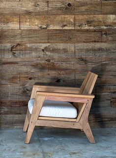 a wooden chair sitting in front of a wall with wood planks on the walls