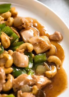 a white plate topped with meat and veggies covered in brown gravy