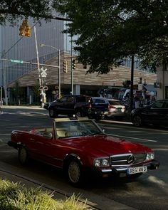 a red convertible car is parked on the side of the road