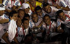 the soccer players are posing for a team photo with their trophy in front of them