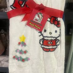 the hello kitty towel is on display in a store with red ribbon around it's neck