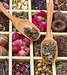 several wooden spoons filled with different types of tea