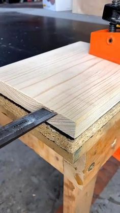 a piece of wood being cut with a planer on it's end and an orange object in the background