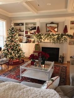 a living room filled with furniture and a christmas tree in front of a fire place