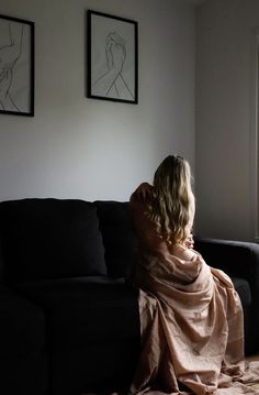 a woman wrapped in a blanket sitting on a couch