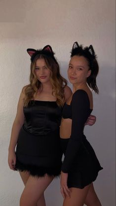 two women dressed up in cat costumes posing for the camera with their arms around each other