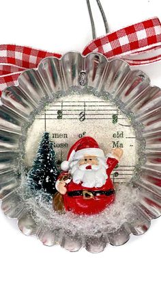 a glass ornament with a santa clause holding a christmas tree and music notes