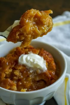 a spoon with some food in it on top of a white bowl next to a napkin