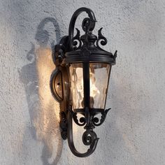 an old fashioned wall light on the side of a building with stucco walls behind it