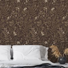 a bed sitting next to a brown wallpaper with flowers on it