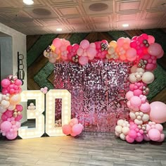 a large balloon arch with pink and white balloons