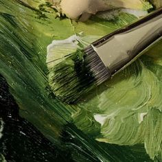 a brush is sitting on top of some green paint